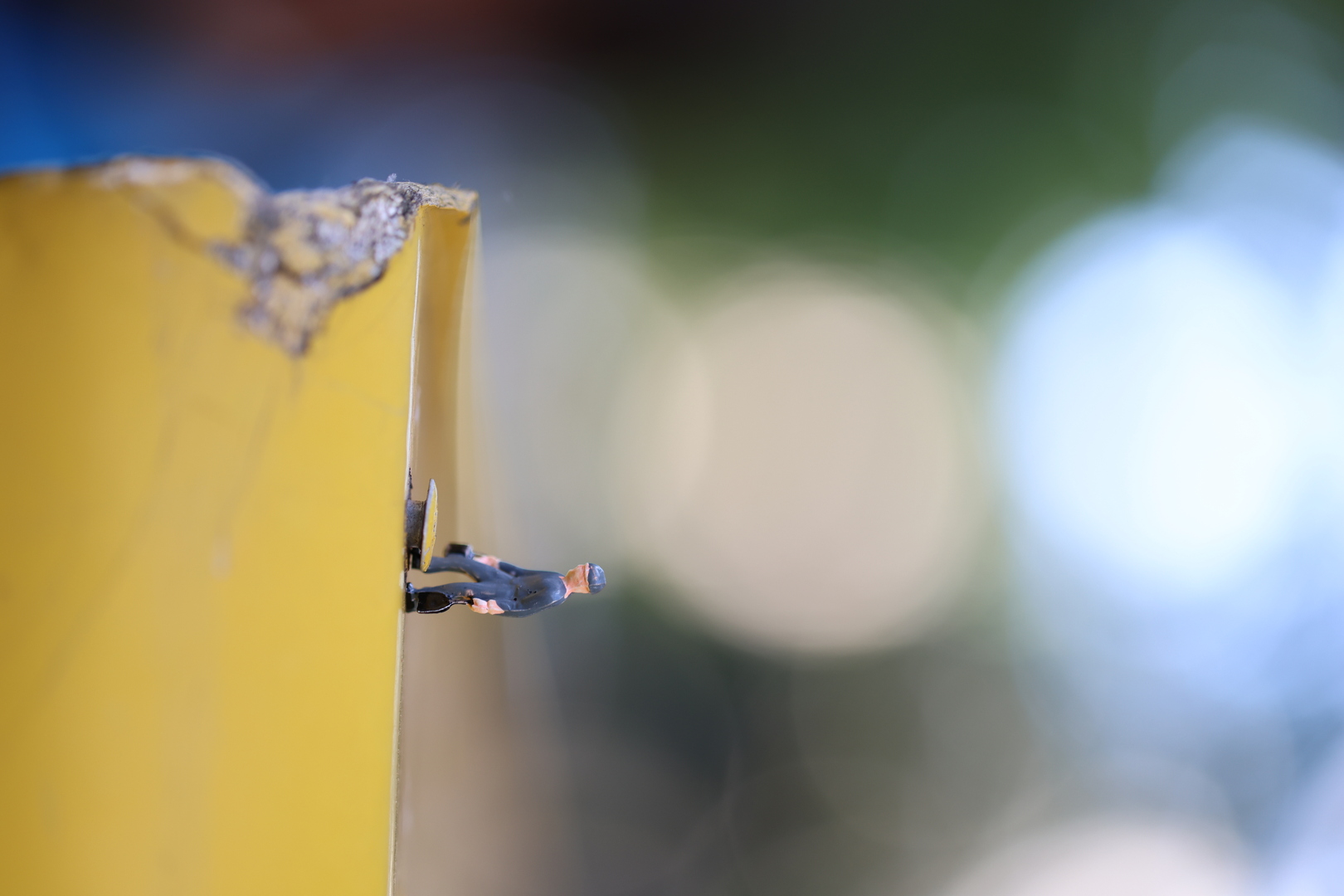 Macro image of plastic figurine on yellow postbox